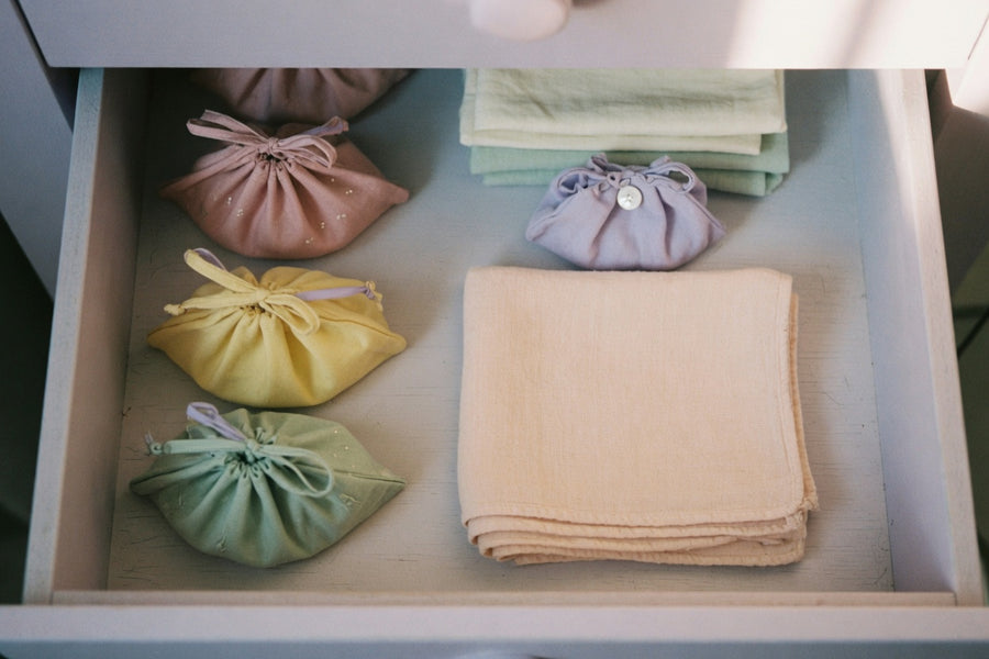 Closed matte storage pouch and a clean silicone toy on dark linen — sex toy storage after wash and full dry